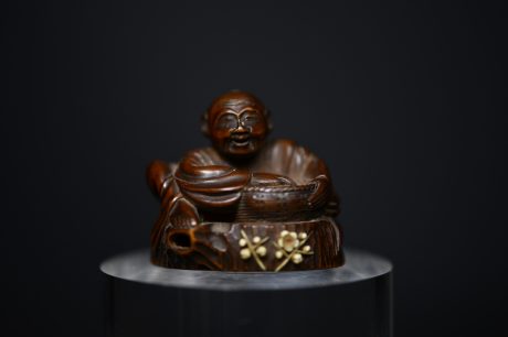Netsuke man on stump wood
